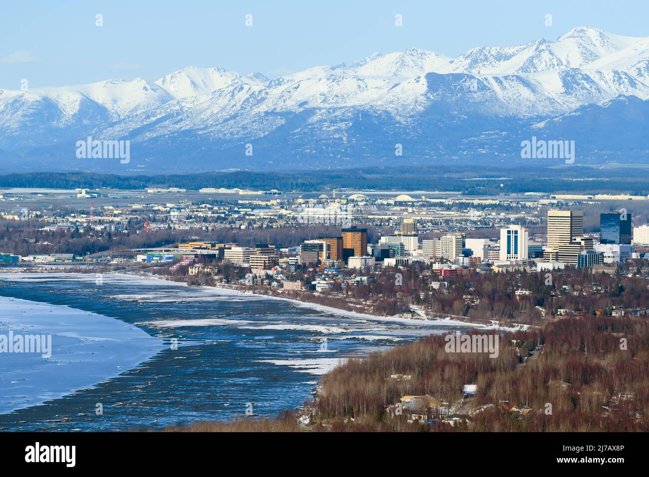 Anchorage city aerial view in Alaska with mountain range behid. Anchorage downtown skyline and mountain with snow. Alaska city from above. Stock Photo