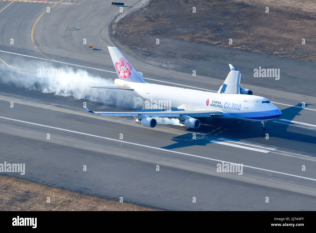 China Airlines Cargo Boeing 747 freighter aircraft hard landing. Large cargo airplane 747-400F aerial view. Plane 747F arrival. Landing gear smoke. Stock Photo