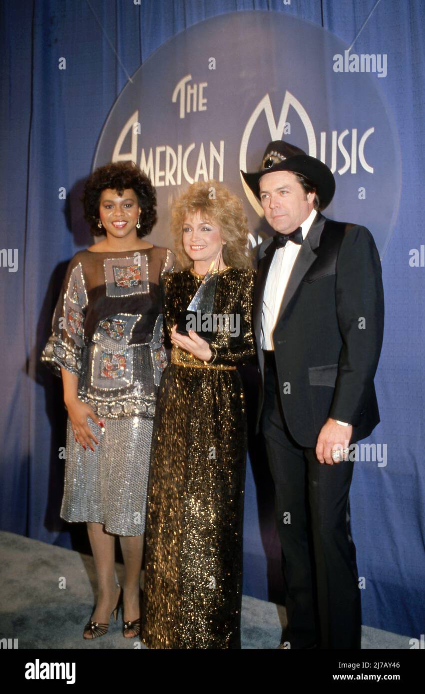 **FILE PHOTO** Mickey Gilley Has Passed Away.  Deniece Williams, Barbara Mandrell and Mickey Gilley at the 10th Annual American Music Awards at Shrine Auditorium in Los Angeles, California January 17, 1983 Credit: Ralph Dominguez/MediaPunch Stock Photo