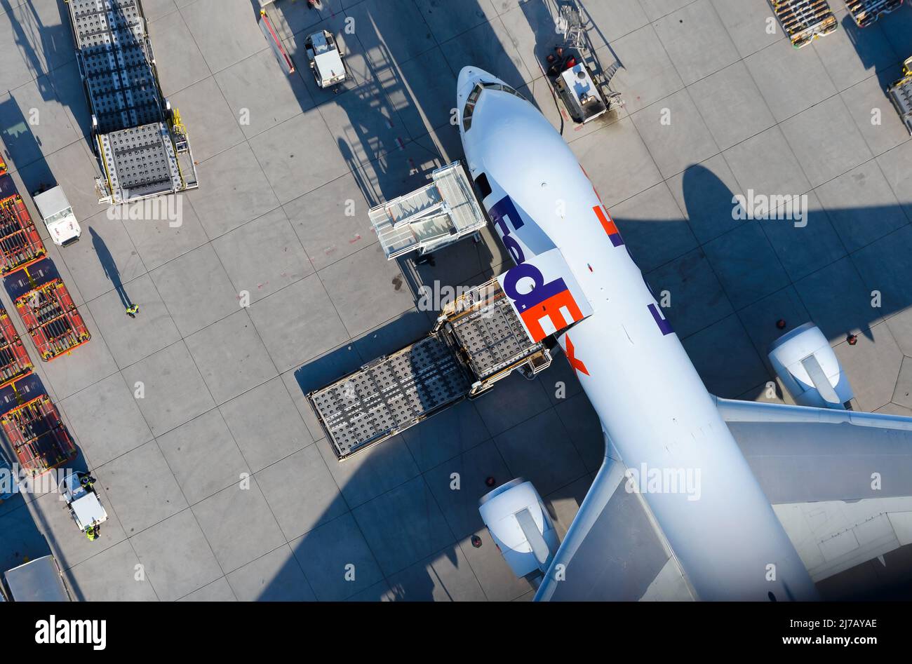 FedEx Boeing 767 aircraft being loaded with cargo. Freighter airplane of Fedex Express with cargo door open seen from above. Air cargo plane. Stock Photo