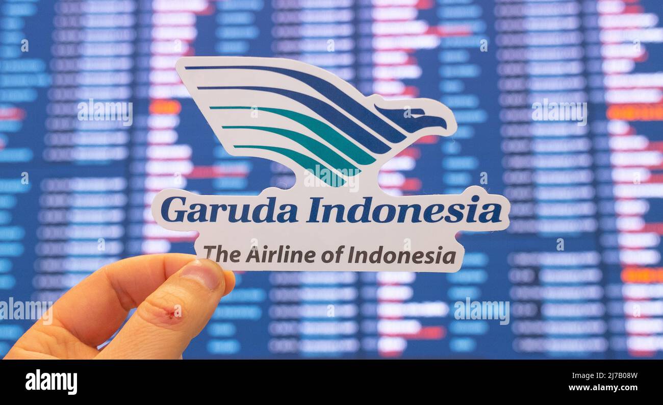 December 11, 2021, Tangerang, Indonesia. The emblem of the Garuda Indonesia airline against the background of an electronic board with the flight sche Stock Photo