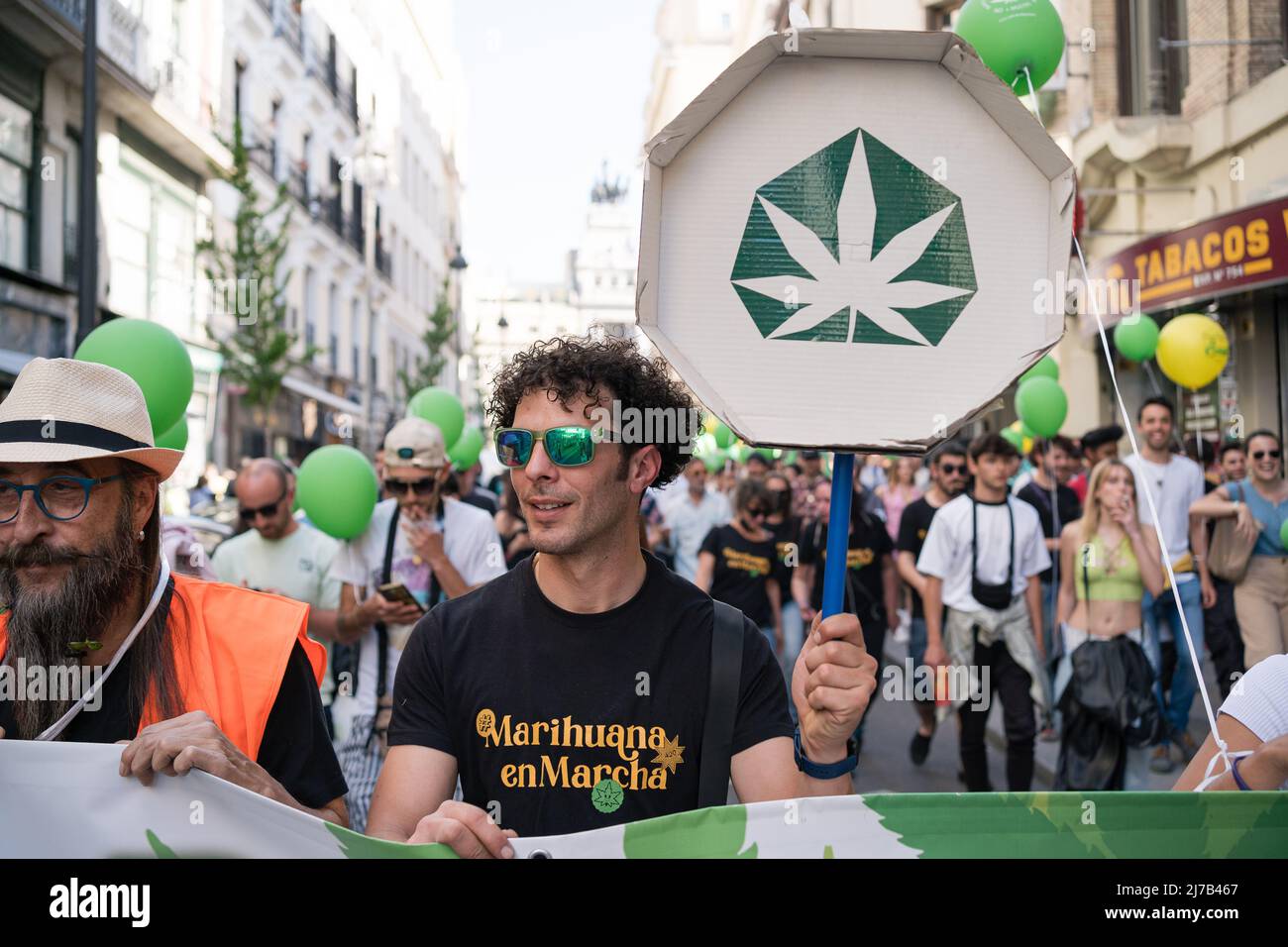 A pro-cannabis protester holds a sign with a marijuana symbol during a demonstration in the center of Madrid. Thousands of pro-cannabis activists took part in a demonstration in La Gran Via in Madrid, Spain, in favor of legalizing the medicinal and recreational use of marijuana. (Photo by Diego Radames / SOPA Images/Sipa USA) Stock Photo