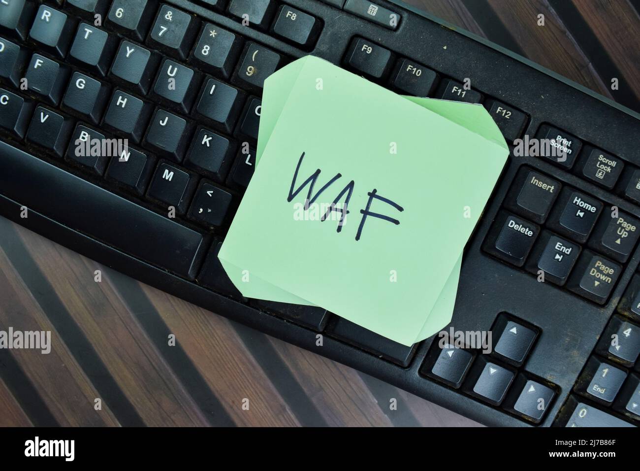 WAF - Web Application Firewall write on sticky notes isolated on Wooden Table. Stock Photo