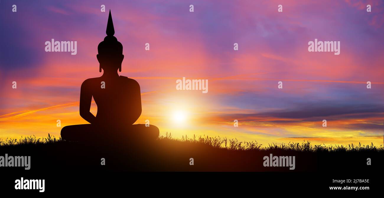 Silhouette of Buddha mediating in the twilight with sunrise background. Magha Puja, Asanha Puja, and Visakha Puja Day. Buddhist holiday Concept. Stock Photo