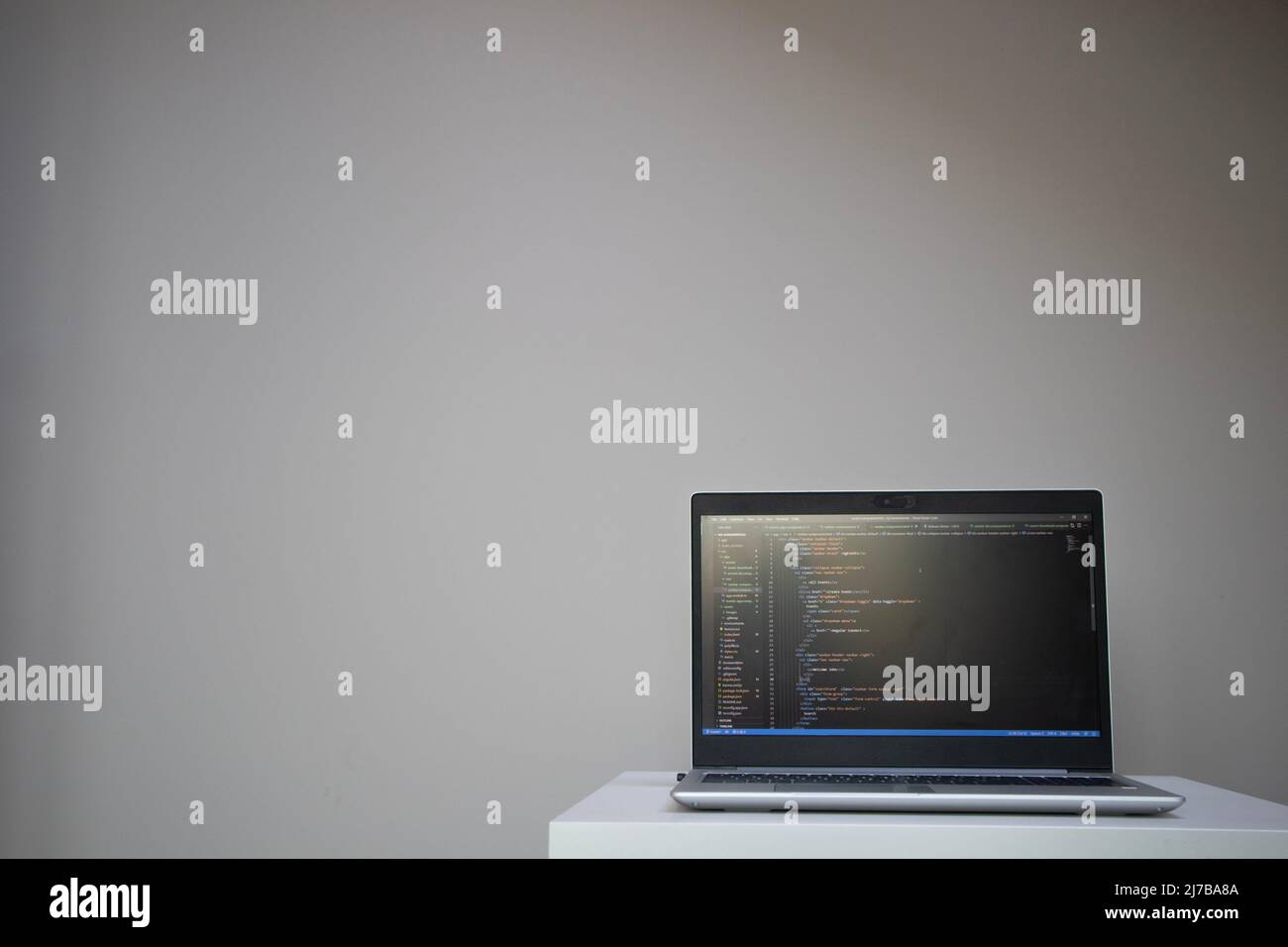 Opened laptop with code on the screen on the table Stock Photo