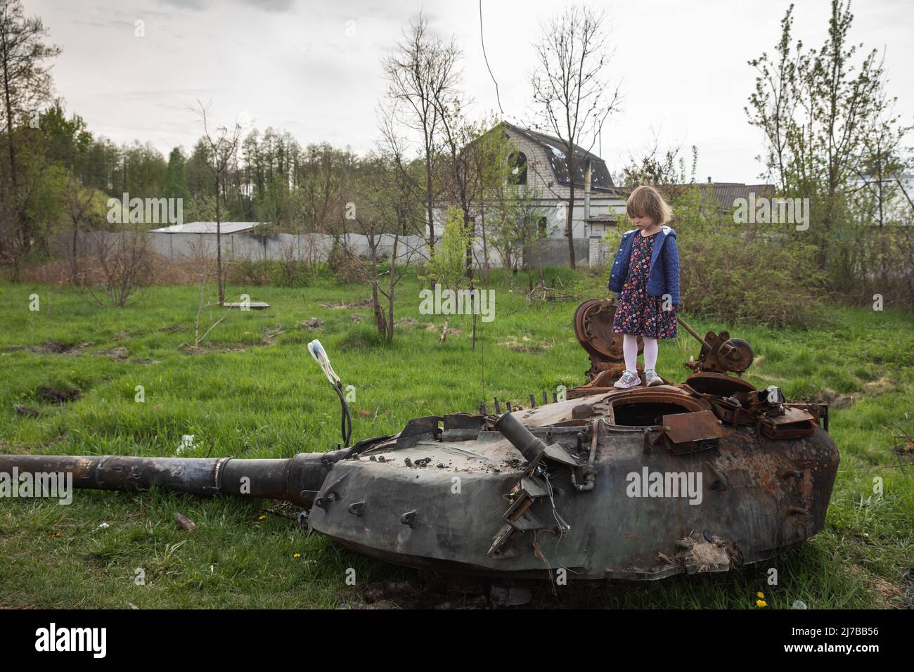 A girl stands on the tower of a destroyed Russian tank near Makariv village, Kyiv region. Russia invaded Ukraine on 24 February 2022, triggering the largest military attack in Europe since World War II. Stock Photo