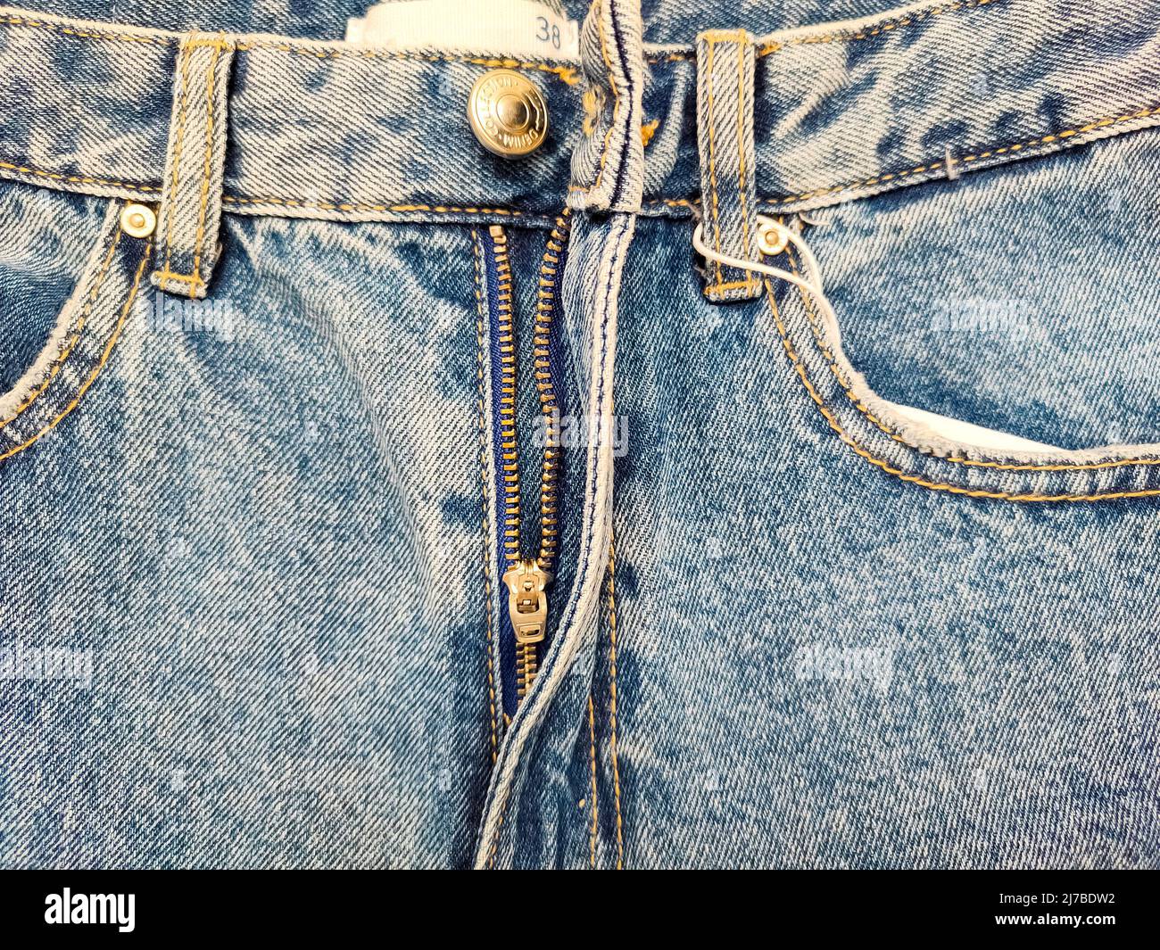 Finger sticking out of blue jeans fly open - a Royalty Free Stock