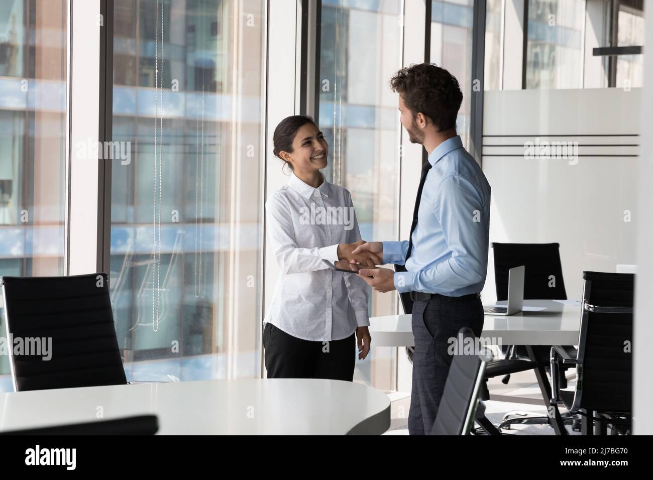 Two diverse confident business man and woman shaking hands Stock Photo