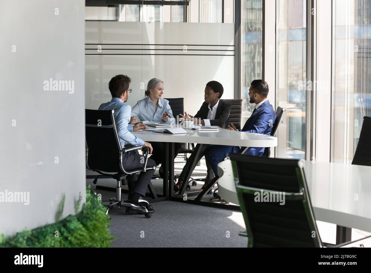 Multiethnic business team discussing project in meeting room Stock Photo