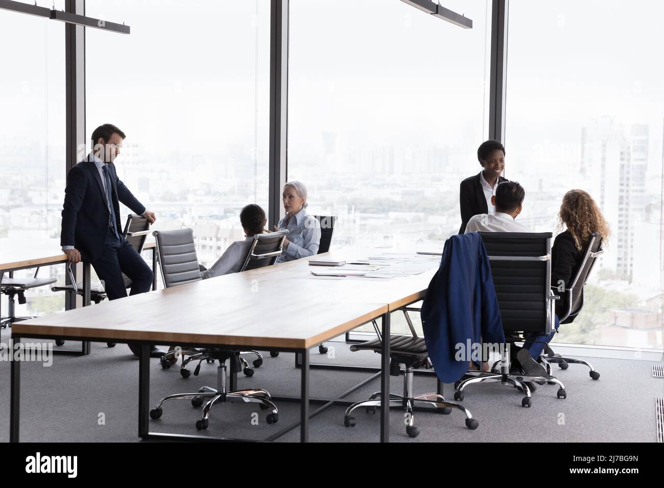 Two diverse business team gathering separately in modern office Stock Photo