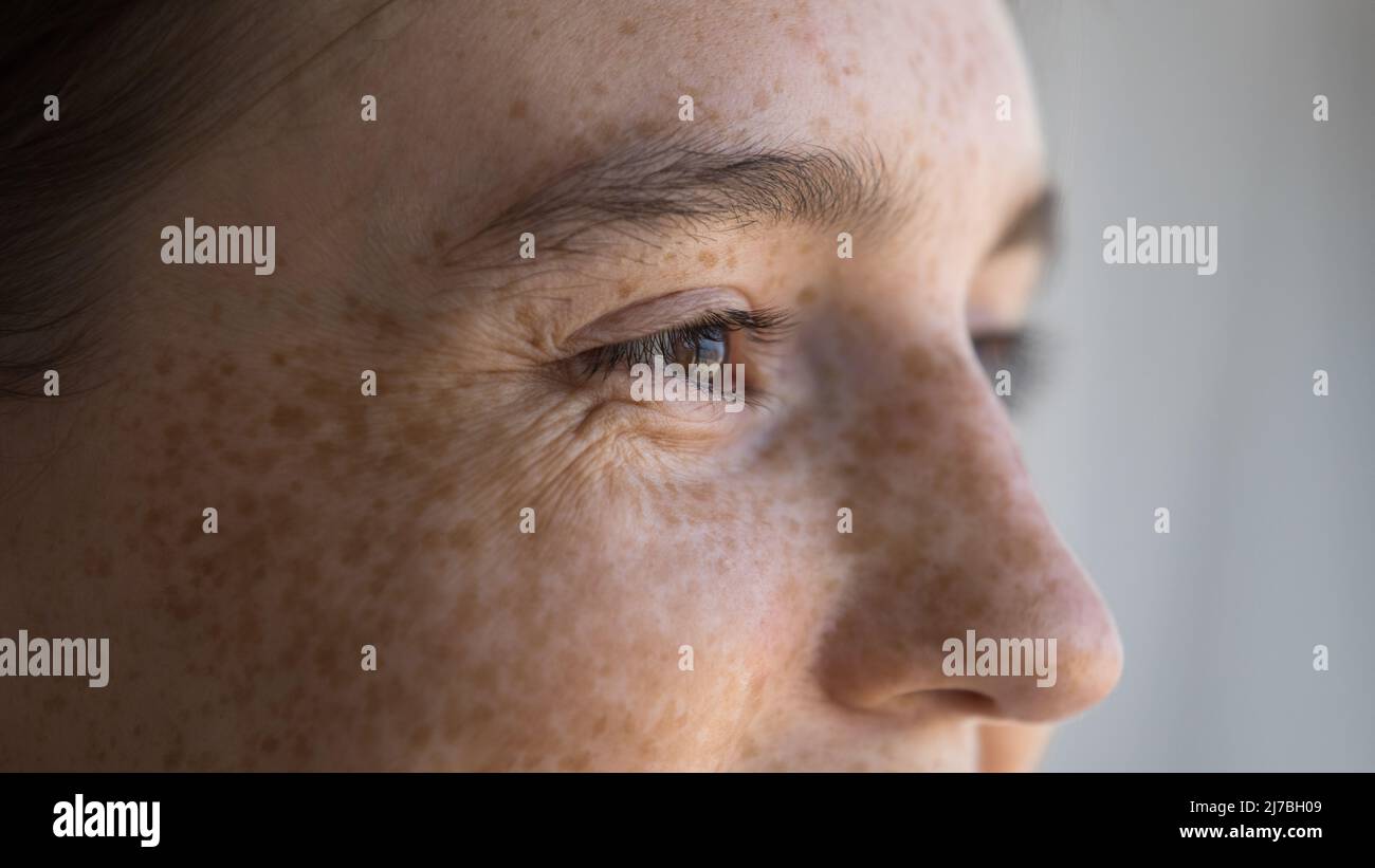 Cheerful freckled young woman looking away, smiling, laughing Stock Photo