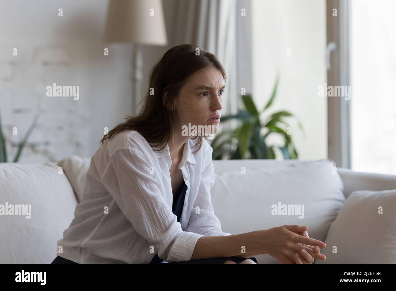 Concerned nervous young woman suffering from anxiety disorder Stock Photo