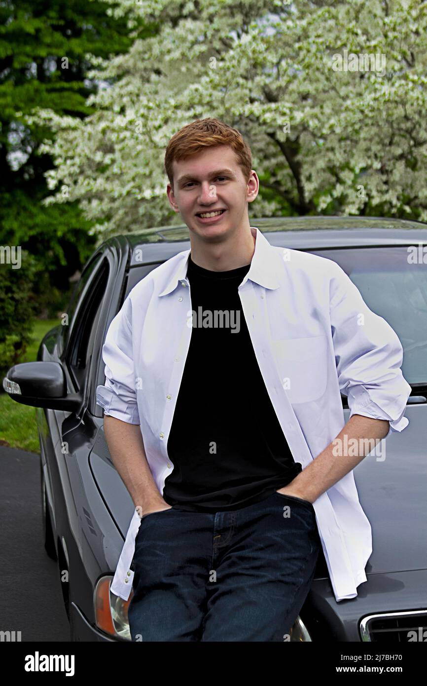 Young Teen Male with auburn hair Standing by His Gray Car Stock Photo