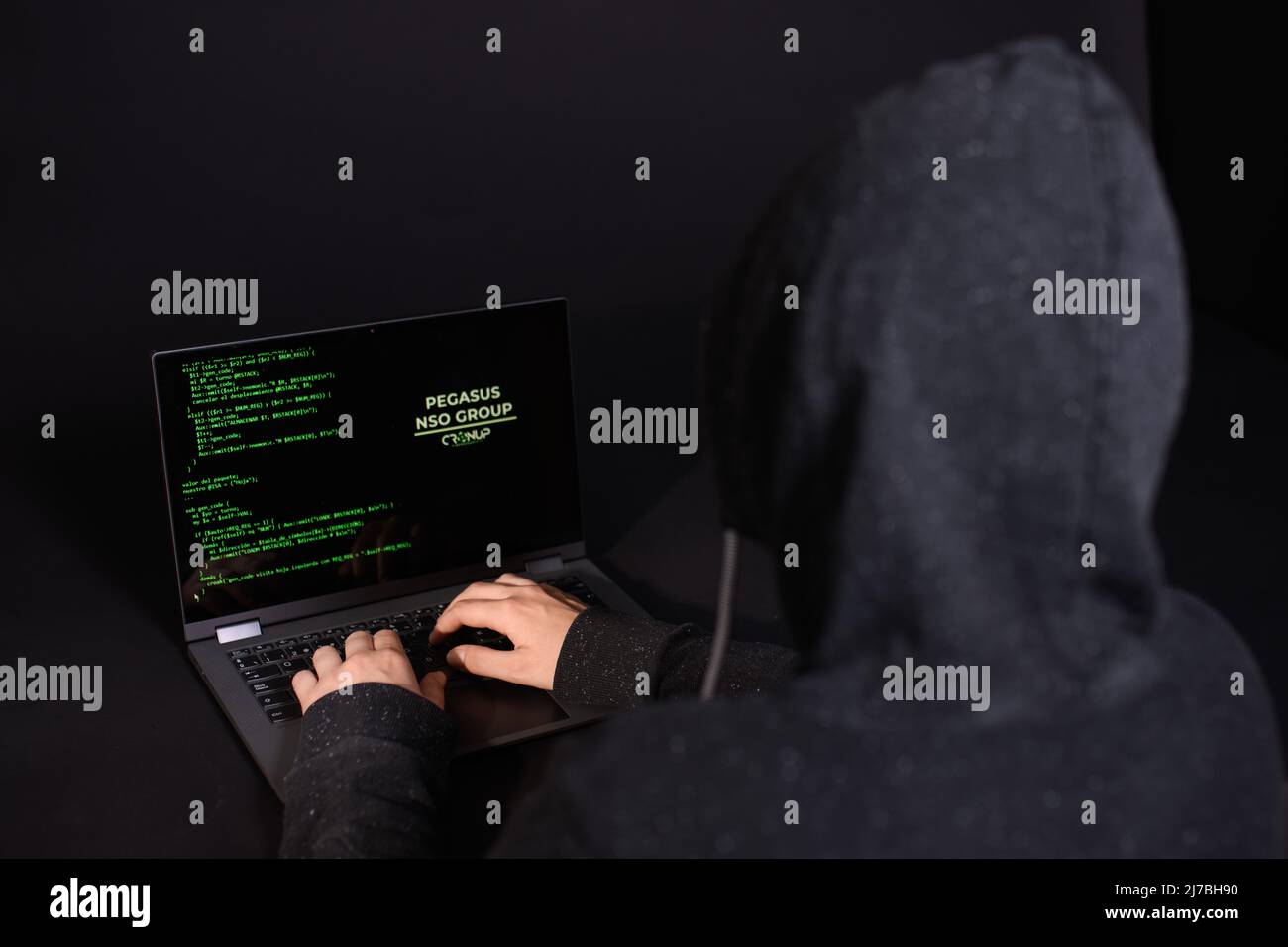 Concept of hacking and malware. Hacker using an abstract laptop with a binary code digital interface. Young hacker in cybersecurity concept. Stock Photo