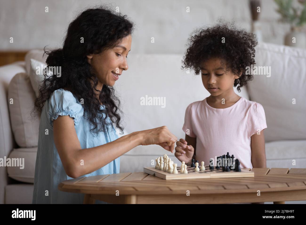 Engaged African mother teaching focused clever preschool daughter Stock