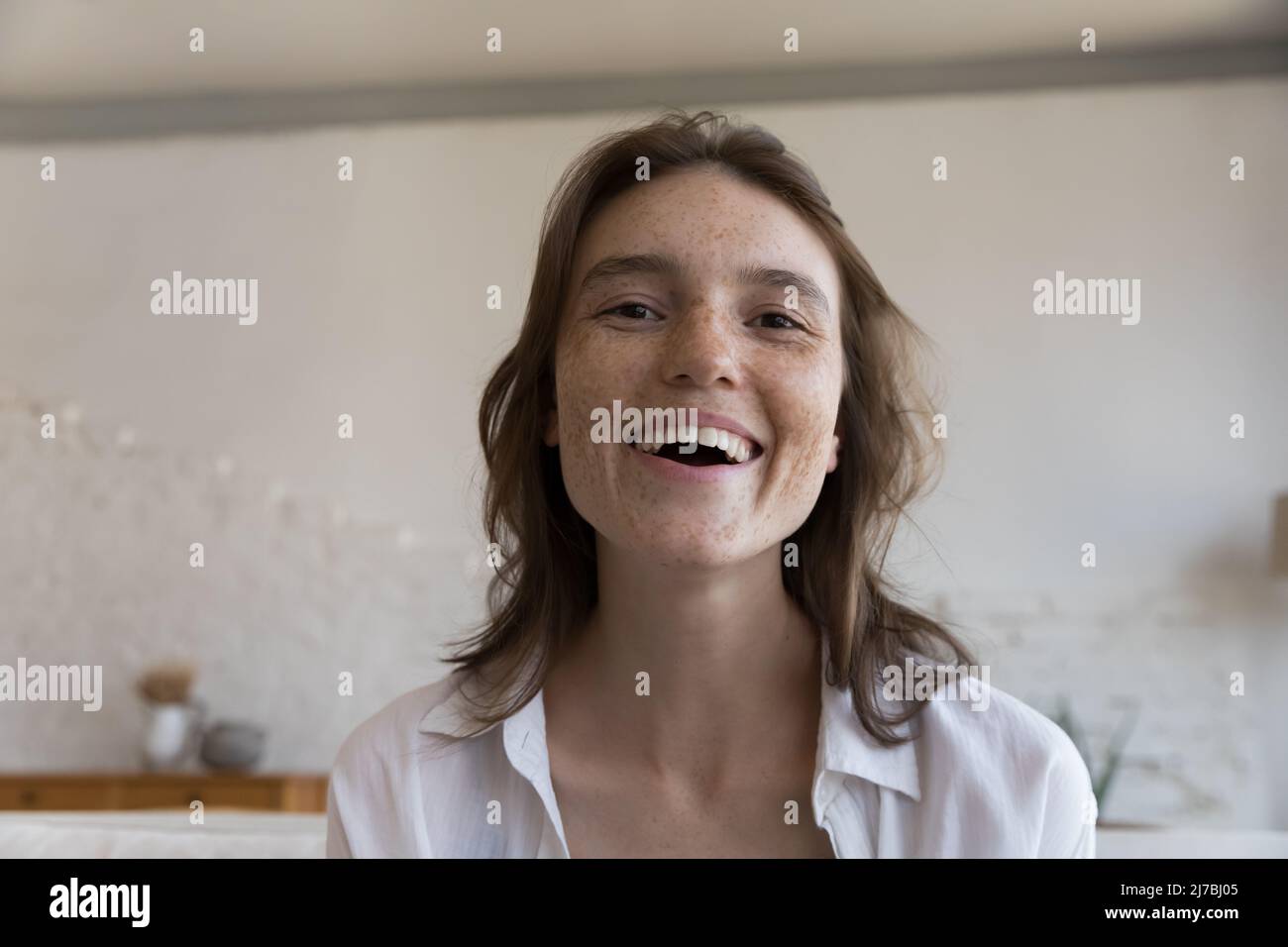 Excited cheerful freckled blogger girl head shot screen view portrait