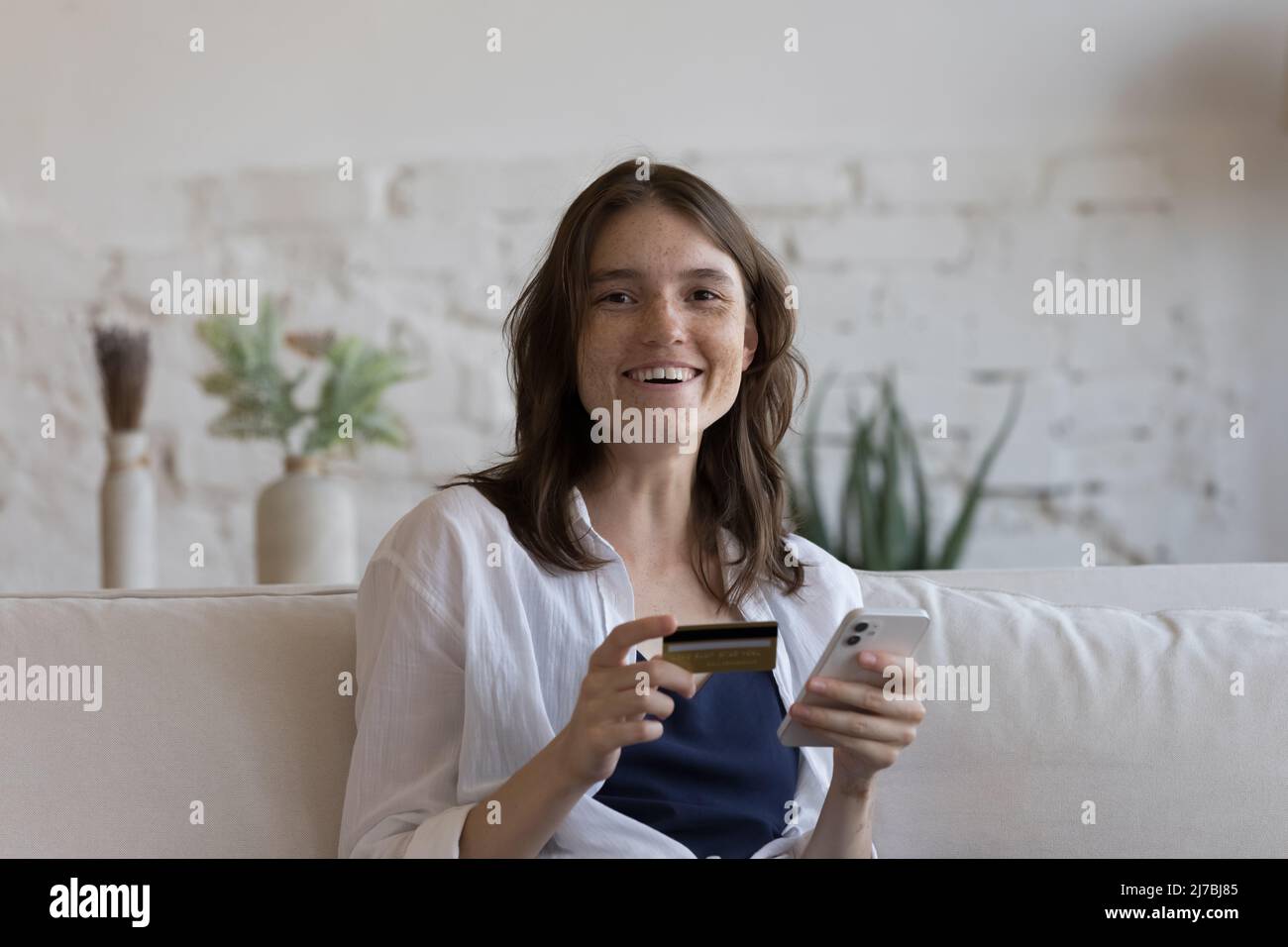 Happy cheerful millennial credit card user girl head shot portrait Stock Photo