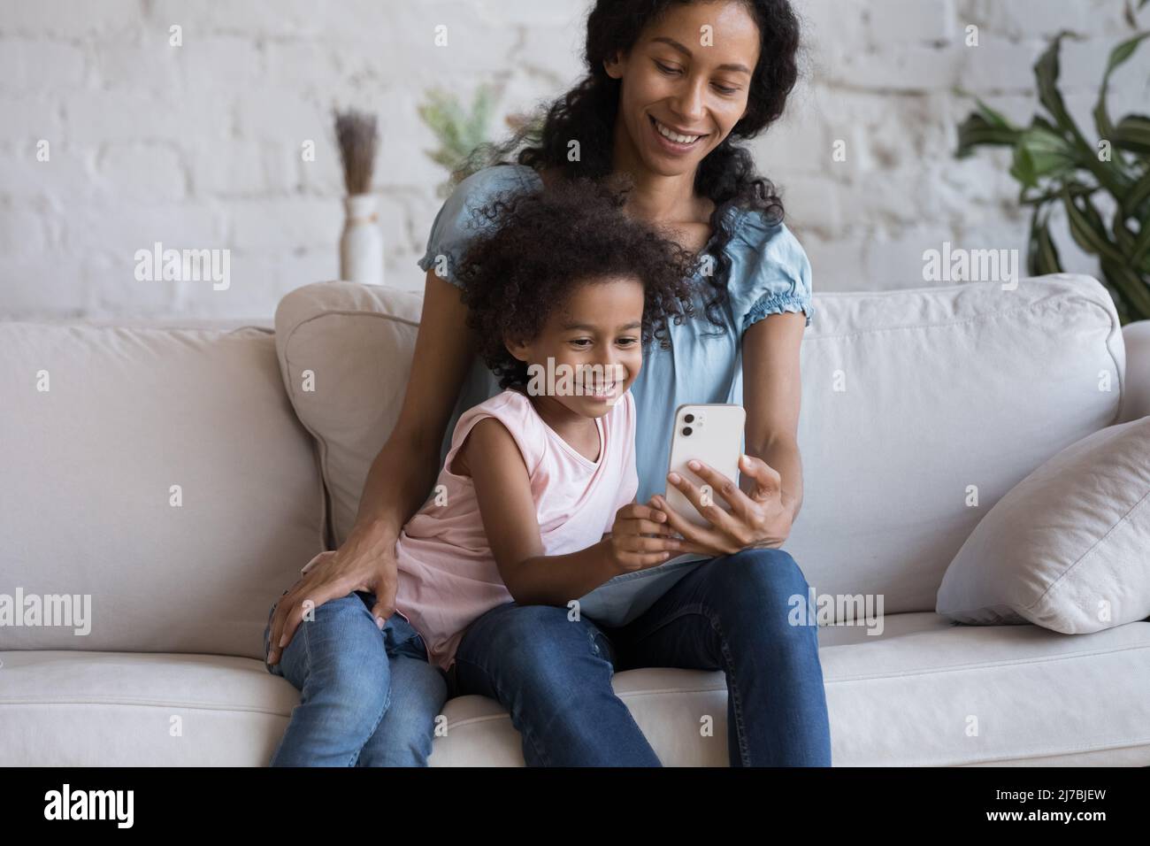 Happy mom and cheerful daughter kid making video call Stock Photo - Alamy