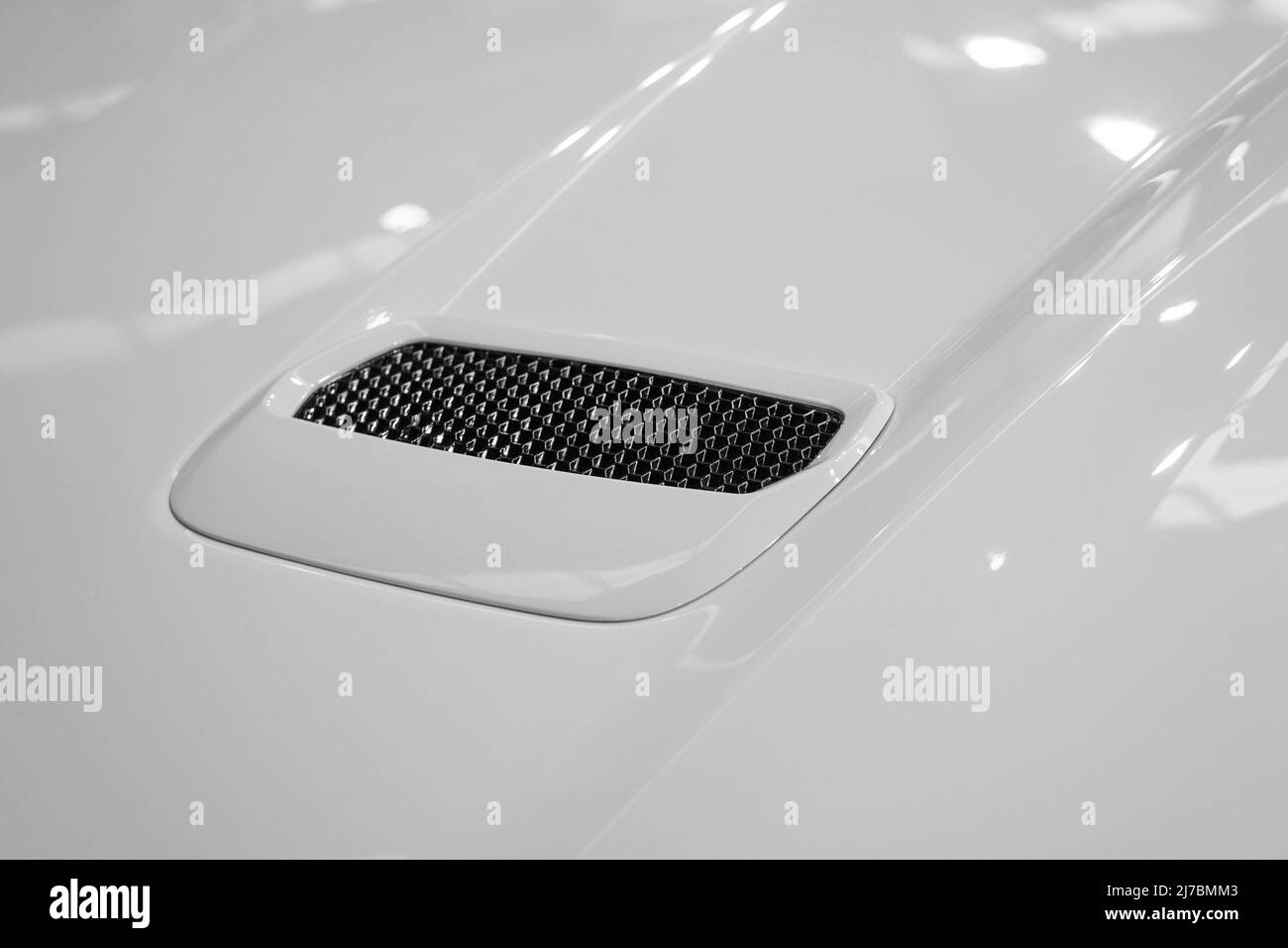 Detail of the exhaust on the hood of a tuned car with white paint Stock