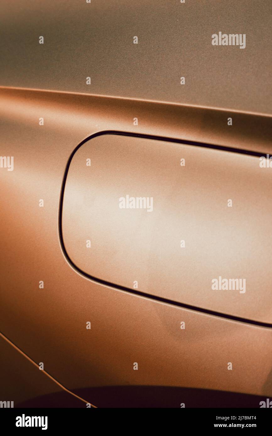 Detail of the fuel tank entry on a golden car with metallic reflections