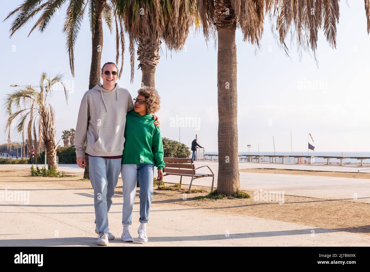 young couple smiling happy while taking a walk Stock Photo