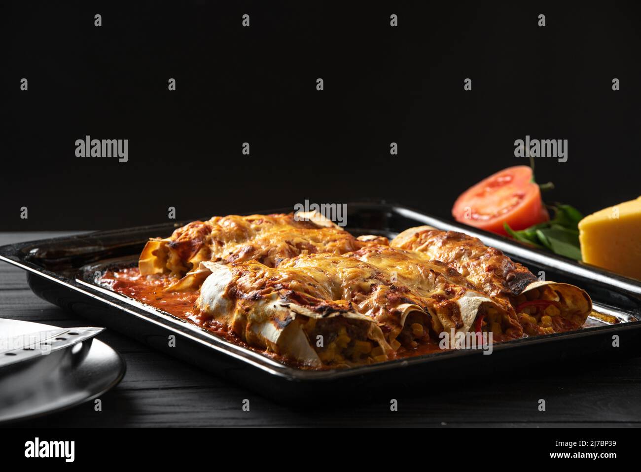 Latino American Food. Enchiladas cooked and standing on a black background Stock Photo