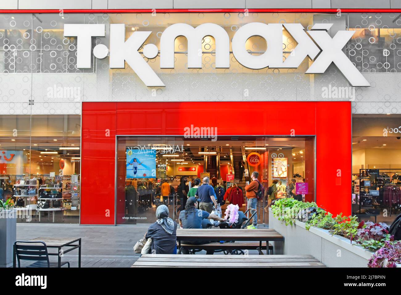 Busy TK Maxx retail clothing business shoppers & red shop front in the  UK Stratford Westfield shopping centre Mall T K Maxx store sign above entrance Stock Photo