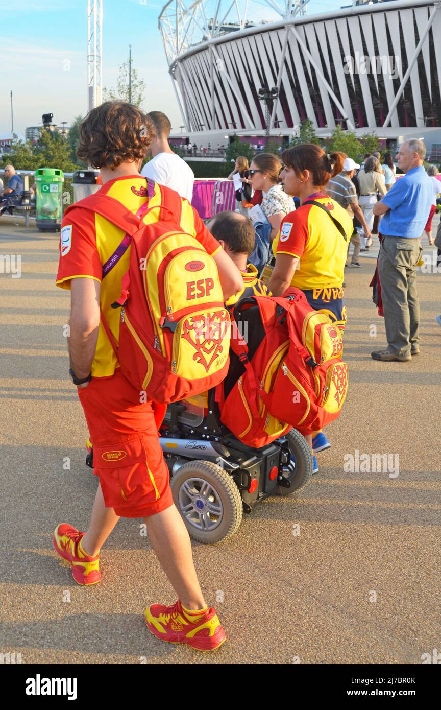Three Spanish athletes wearing official team kit uniforms walking amongst spectators in London 2012 Olympic park at the Paralympics Games England UK Stock Photo