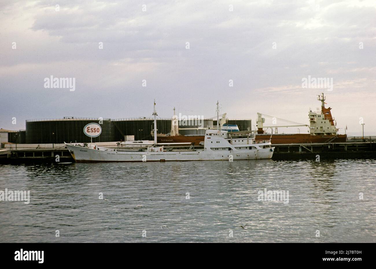 Ship and Esso oil storage tanks, port of Dakar, Dakar harbour, Senegal, West Africa 1978 Stock Photo