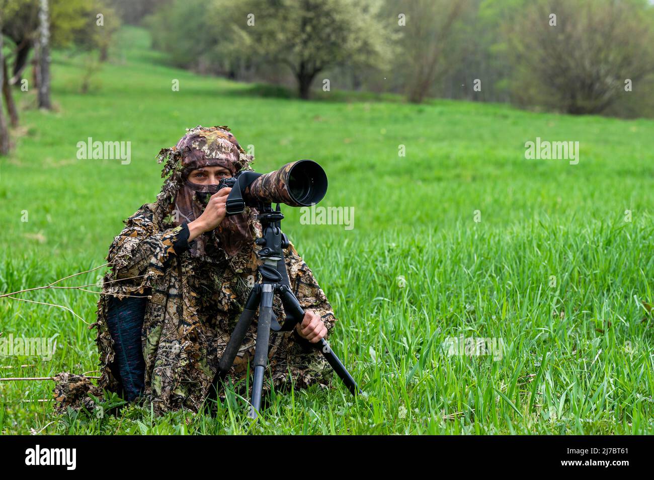 A female nature photographer waiting hidden for an animal Stock Photo ...