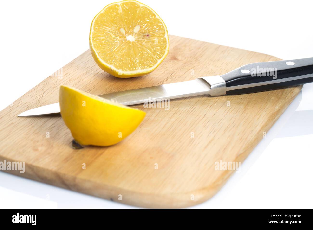 Sliced fresh lemon over chopping board on white background Stock Photo