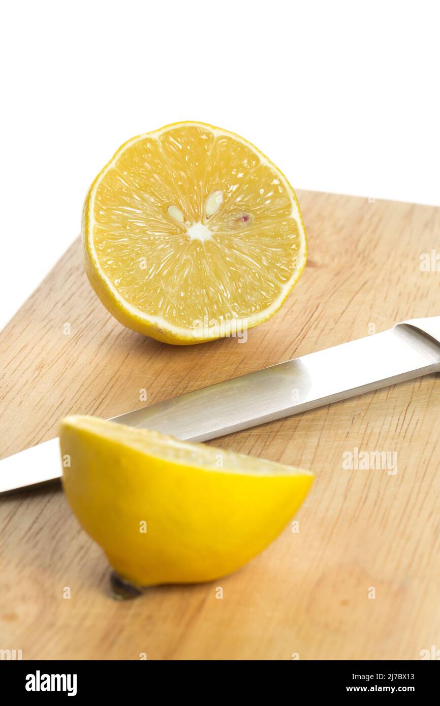 Sliced fresh lemon over chopping board on white background Stock Photo