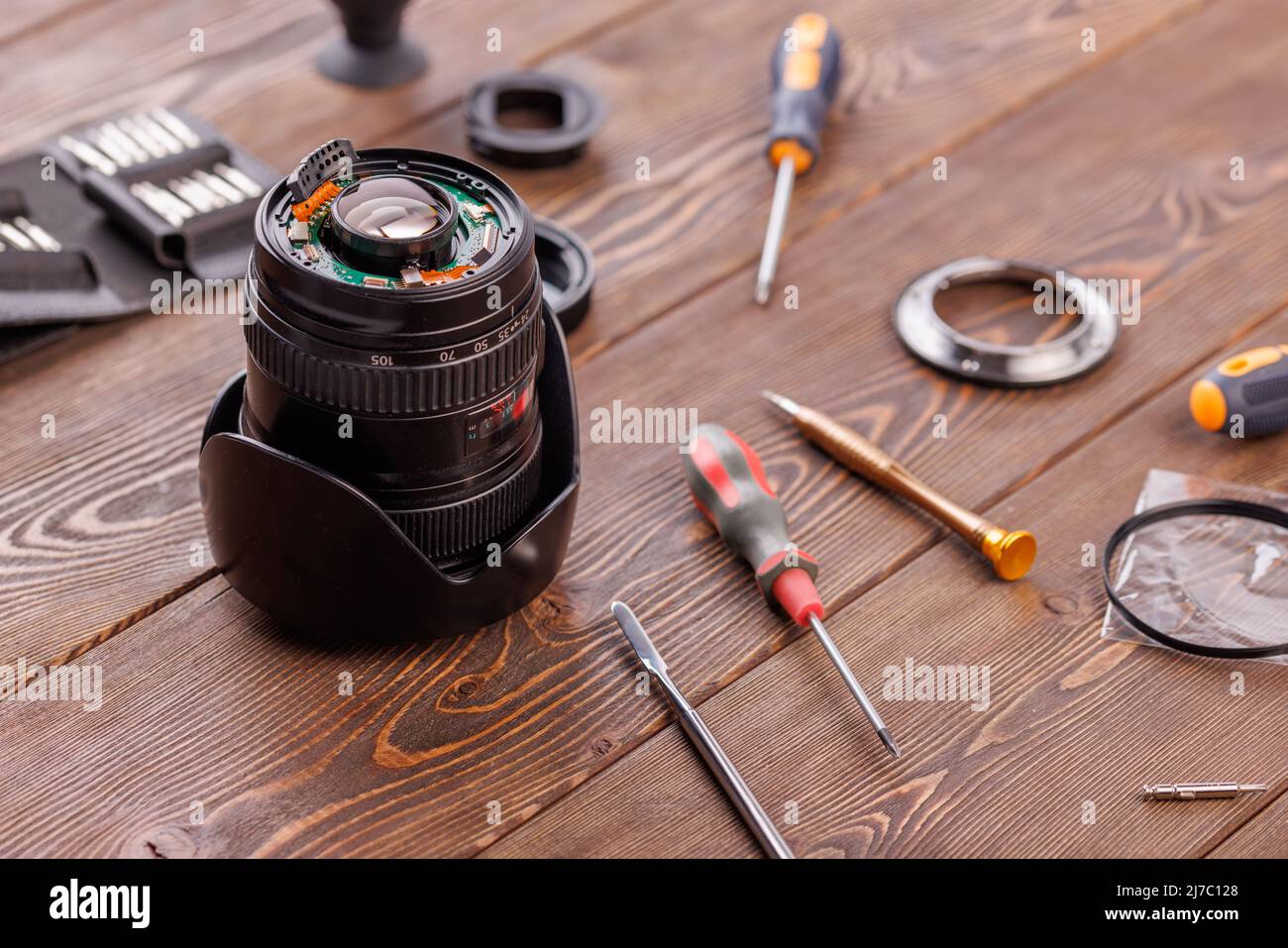 halfdisassembled camera zoom lens on wooden table surrounded with