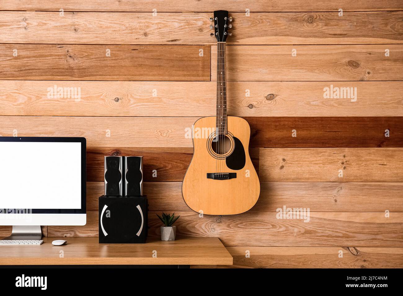 Modern computer and speakers on table near wooden wall Stock Photo - Alamy
