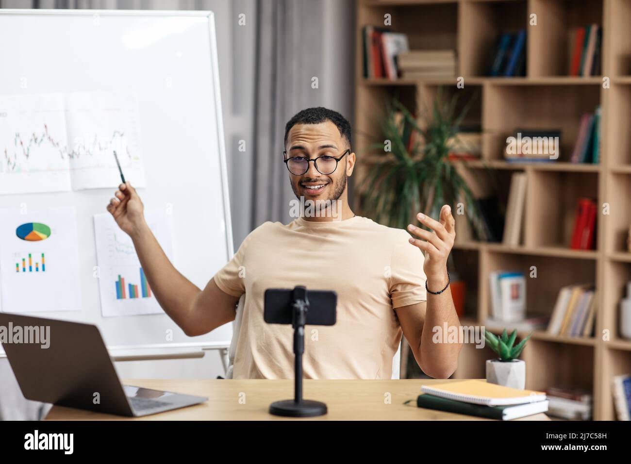 Young arab man making business presentation and demonstrating graphs on whiteboard Stock Photo