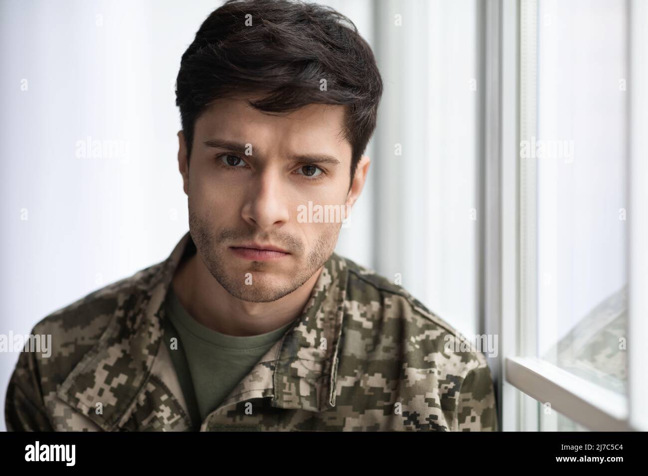 Closeup portrait of upset soldier standing by window Stock Photo - Alamy