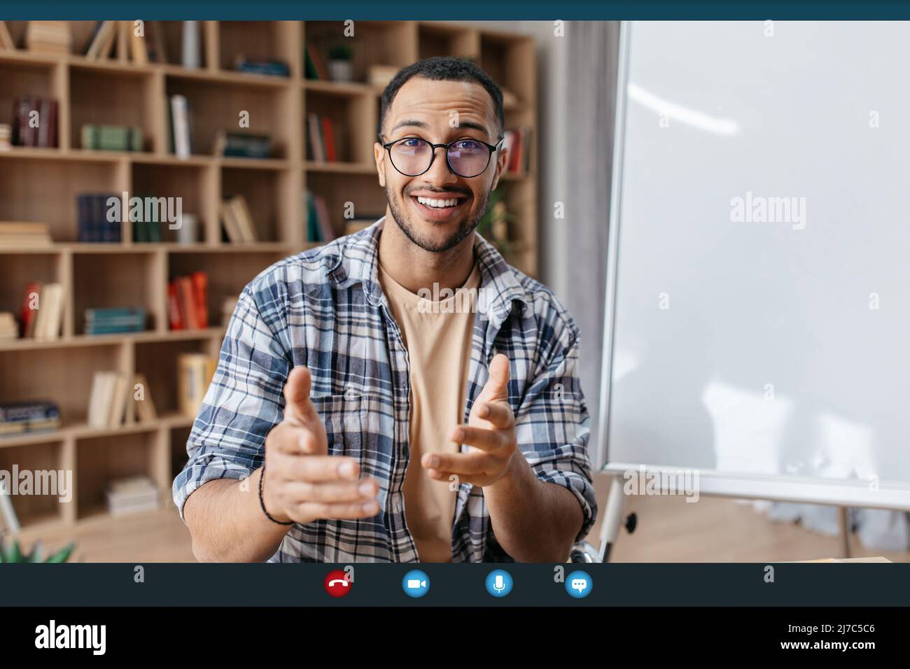 Virtual tutoring concept. Arab male teacher having video call, teaching foreign languages remotely from home Stock Photo