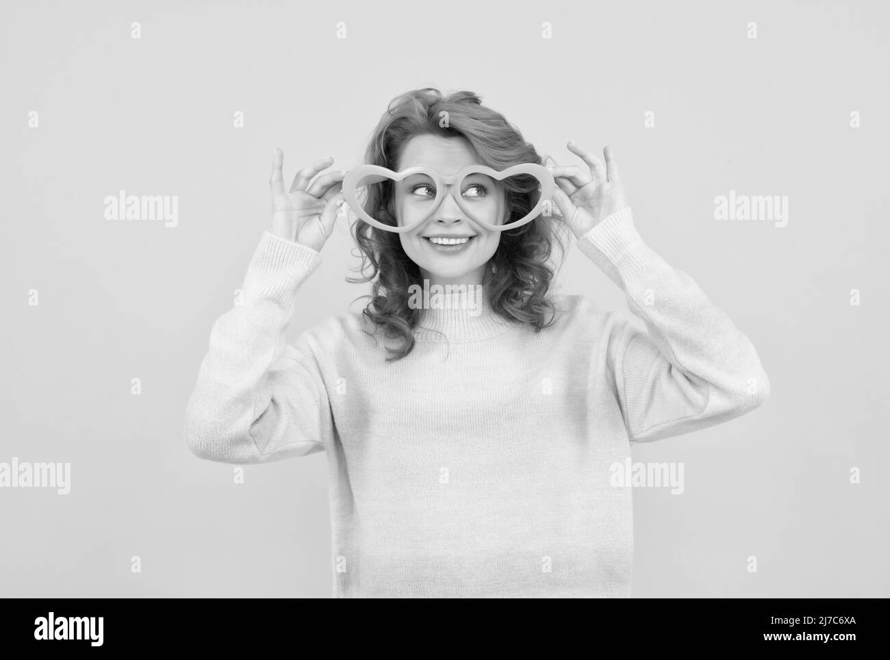 happy redhead woman wear funny party glasses on yellow background, good mood Stock Photo