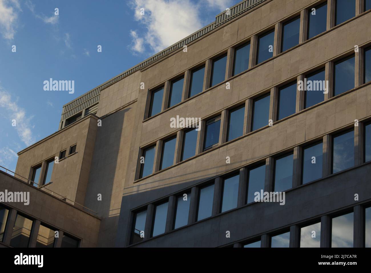 Concrete industrial building with glass windows in the late afternoon