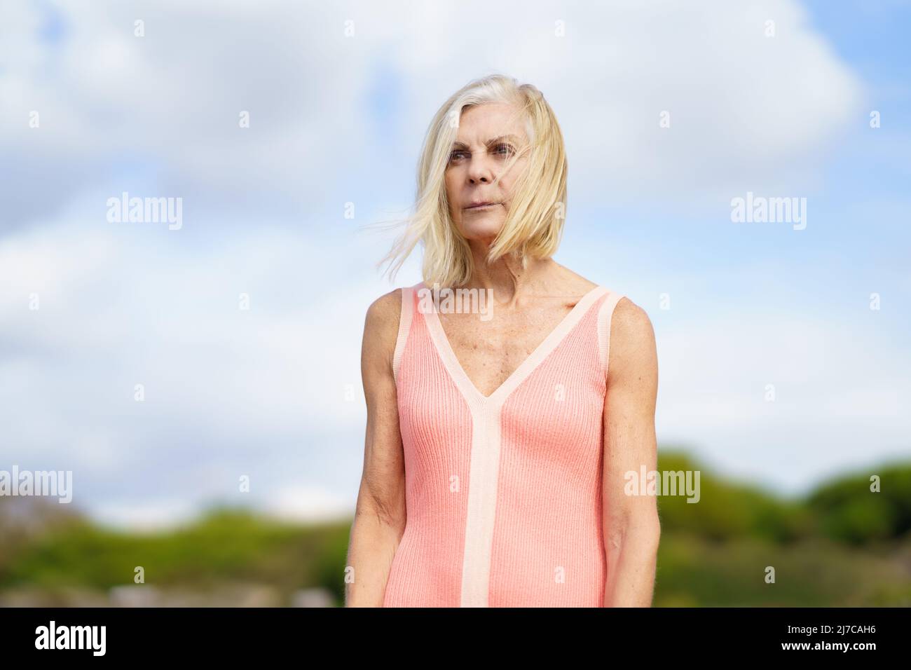 Beautiful mature woman walking along a wooden path near the beach