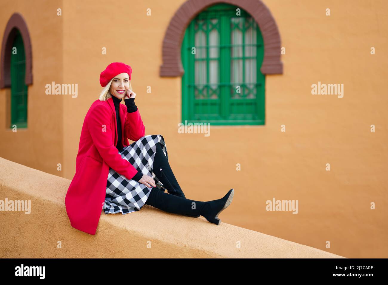 Smiling graceful lady relaxing on old town street during vacation Stock Photo