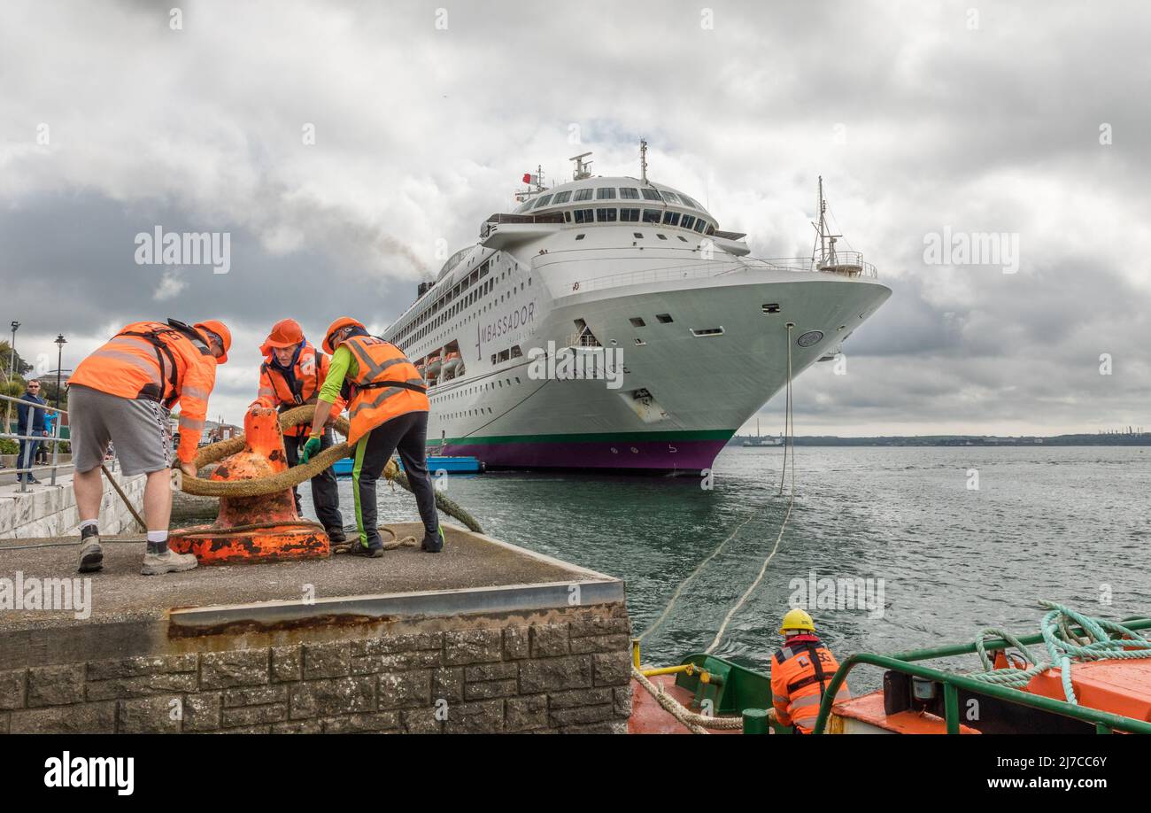 Cobh, Cork, Ireland. 08th May, 2022. Mooring men Eoin Donegan, Danny Grace, Eric Barral with boatman Kevin O'Leary tie up the cruise ship Ambience as she arrives for a visit to Cobh, Co. Cork, Ireland. - Credit; David Creedon / Alamy Live News Stock Photo