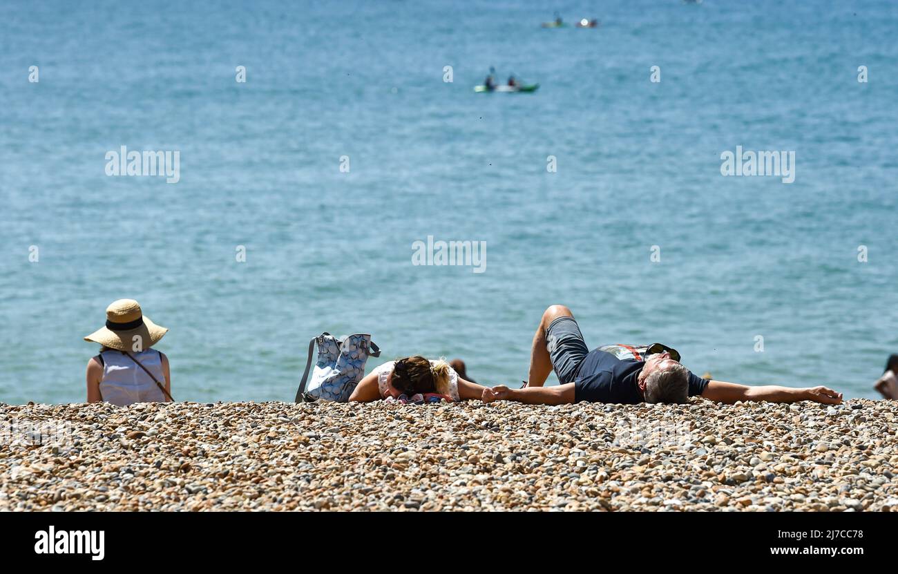 Sunbathers enjoy the warm weather on the beach in brighton hires stock