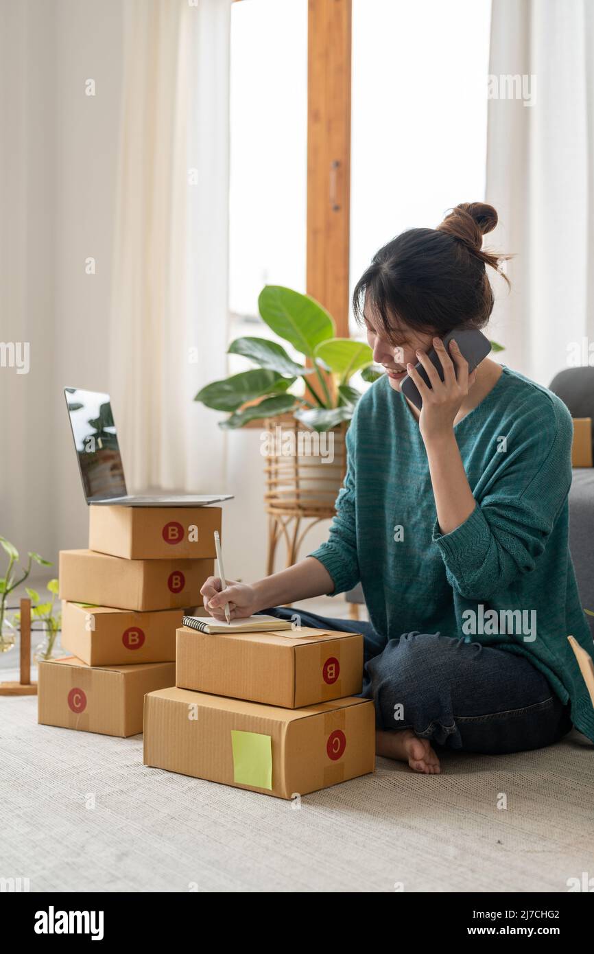 Entrepreneurs Small Business SME Independent woman work at home use  smartphones for commercial checking, online marketing, packing boxes, SME  sellers Stock Photo - Alamy