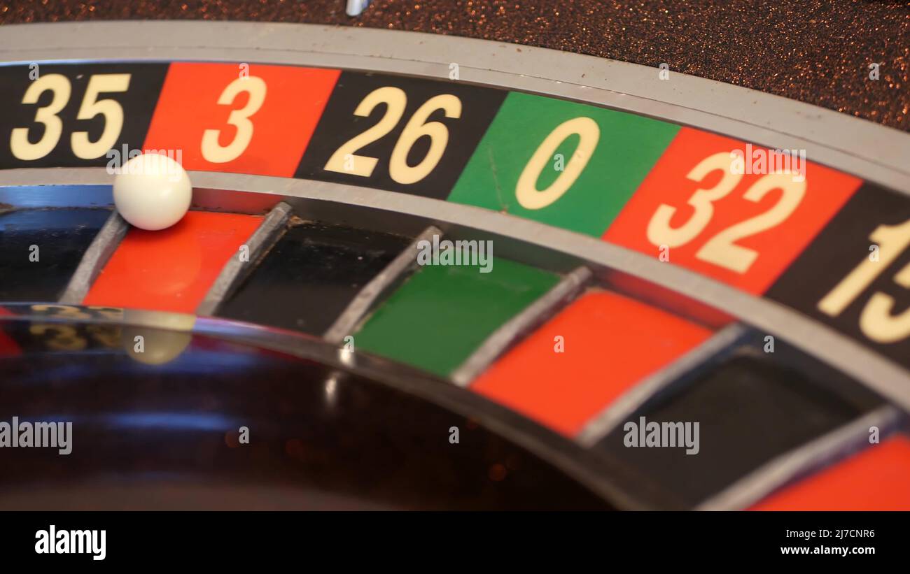 Ball on wooden french roulette table in casino. Wheel spinning, turning or rotating. Odd and even numbers, black, red and zero sectors. Bets in game of chance. Money playing, gambling or risky betting Stock Photo