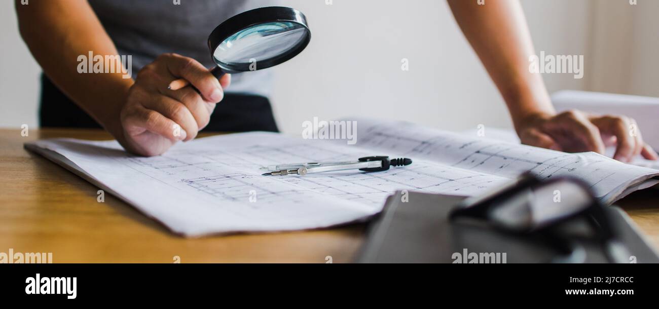 Inspection building concept, Inspector or engineer checking house construction by use magnifying glass on blueprint Stock Photo