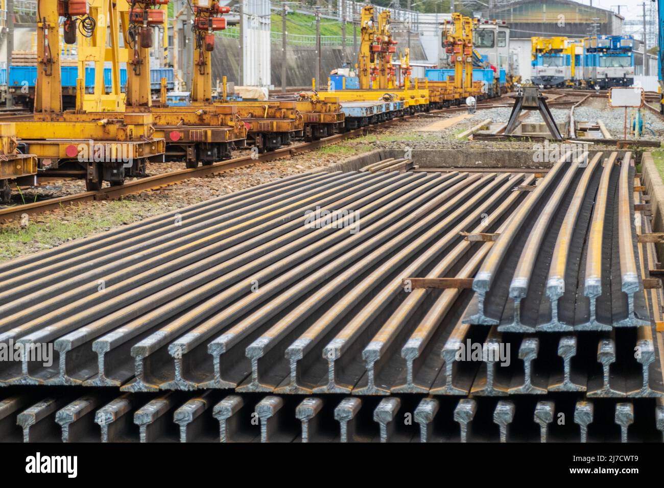 Lengths of rail stacked in train yard Stock Photo Alamy
