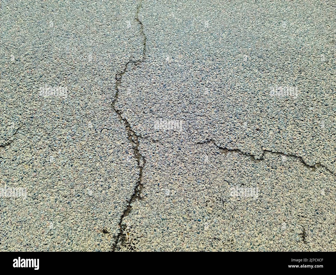 Asphalt surfaces of damaged streets and roads with cracks in a close up