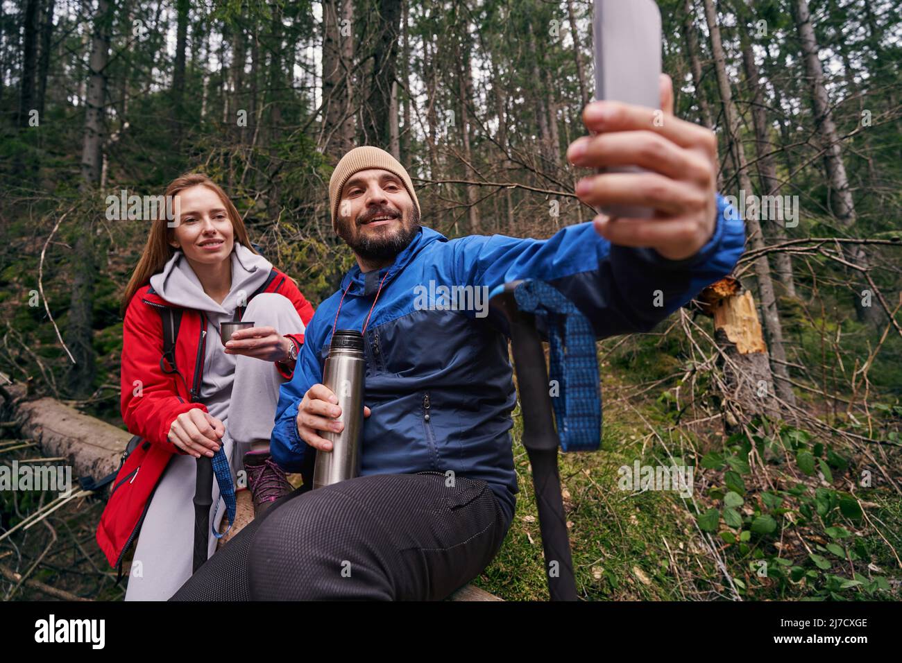 Two hikers on tree making selfie in the woods Stock Photo - Alamy