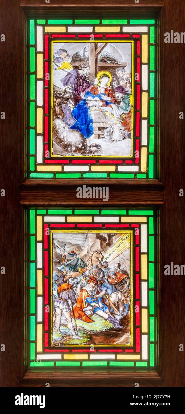 17th century Flemish painted glass, collection of paintings set into a wooden cabinet in St Bartholomew's Church, Haslemere, Surrey, England, UK Stock Photo
